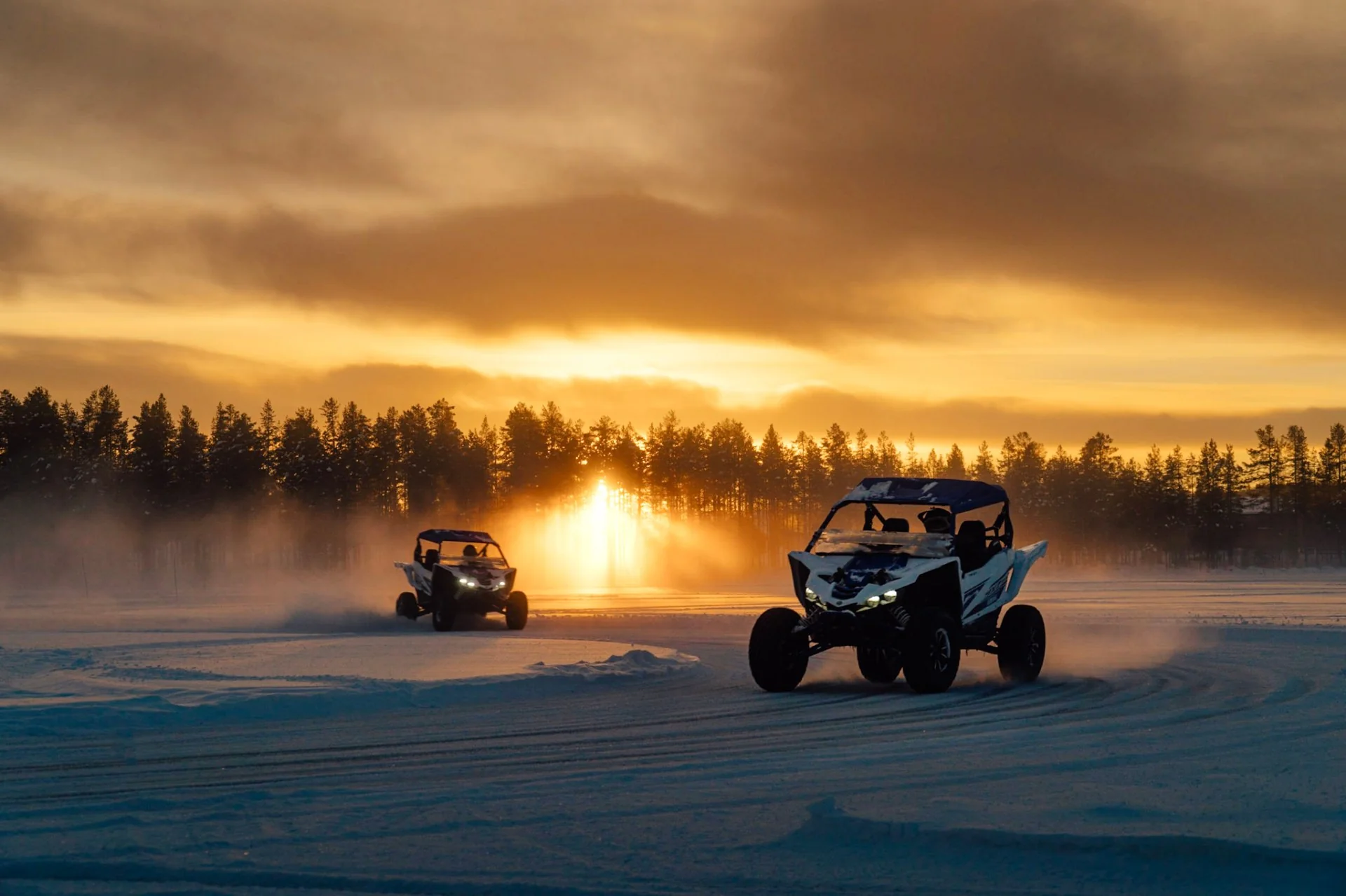 Off-road buggy sliding through a snowy forest track with snow spraying behind it.