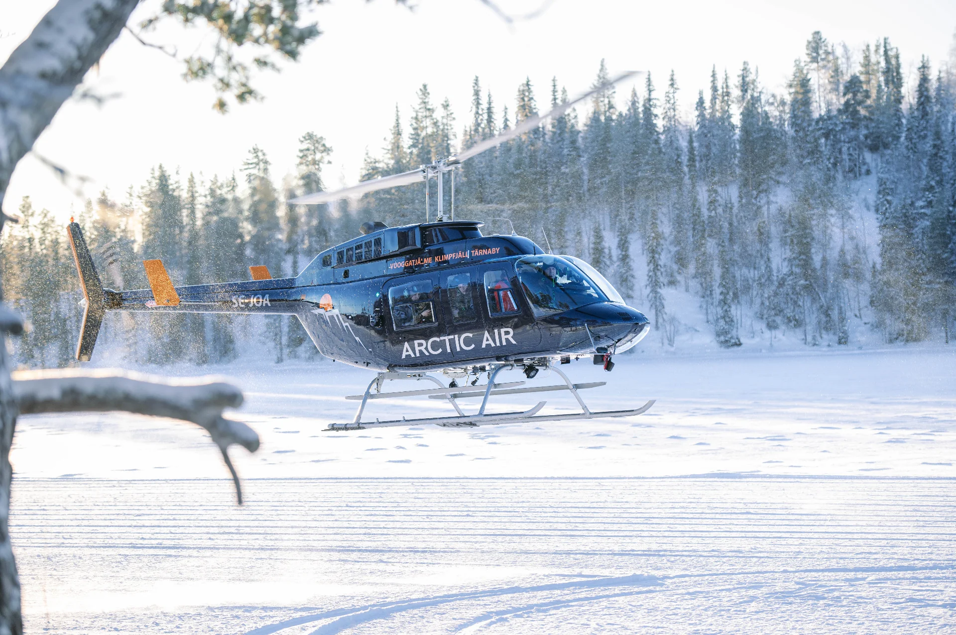 Helicopter landed on a snow-covered plateau overlooking the frozen Lapland wilderness.