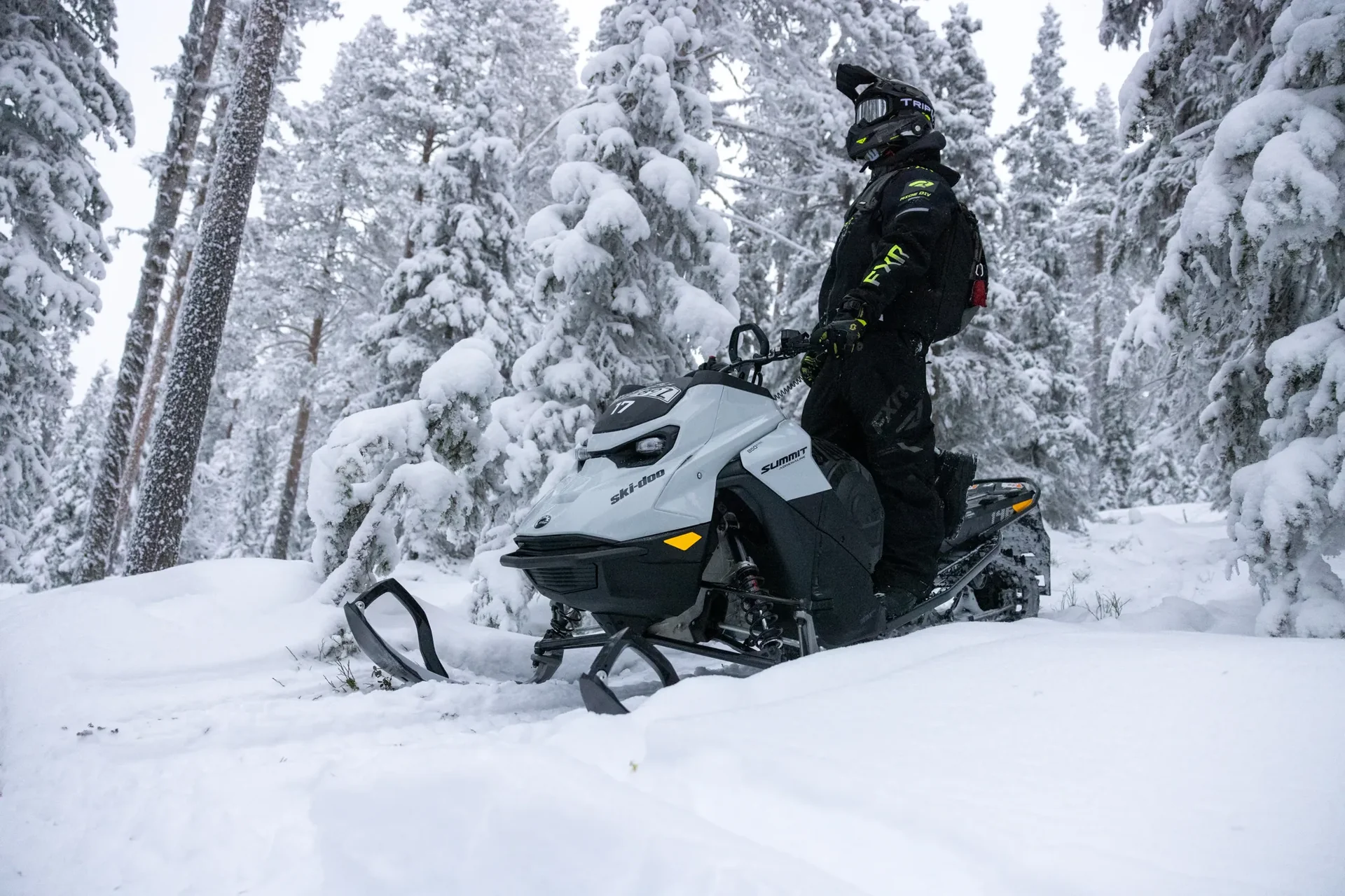 Guests riding snowmobiles across a snow-covered frozen lake in Swedish Lapland at dusk.